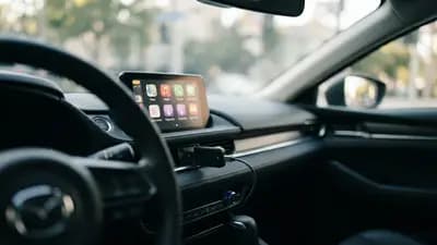 Adaptador compacto Ottocast conectado à porta USB de um painel de carro exibindo interface Apple CarPlay no visor