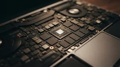 Close em placa lógica interna de MacBook Air com foco em chips de memória soldados à placa-mãe do dispositivo.