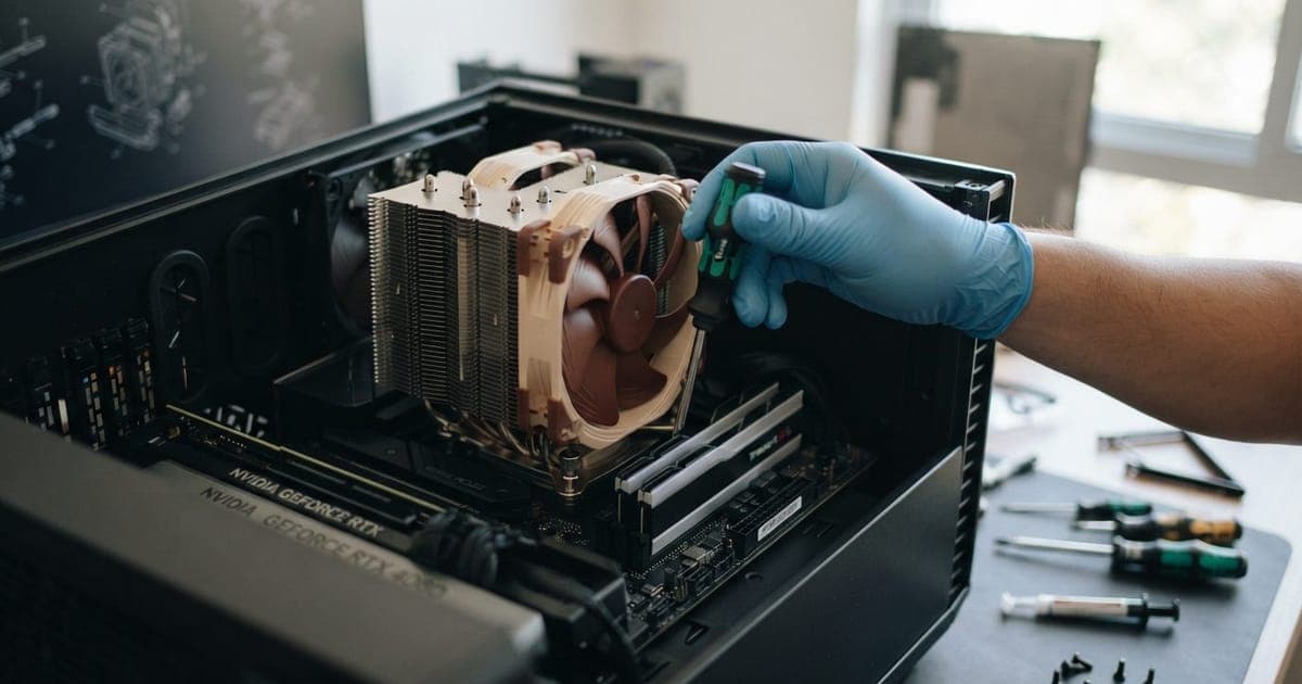 Close em um cooler de processador da Noctua sendo instalado em uma placa-mãe dentro de um gabinete de PC aberto.