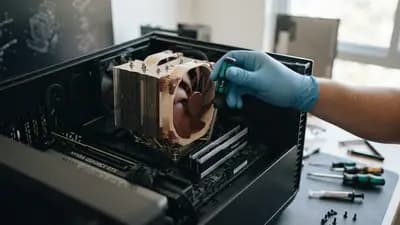 Close em um cooler de processador da Noctua sendo instalado em uma placa-mãe dentro de um gabinete de PC aberto.
