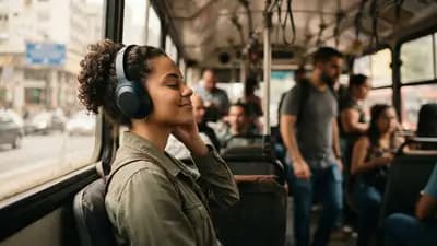 Pessoa usando fone bluetooth com cancelamento de ruído dentro de um ônibus urbano movimentado