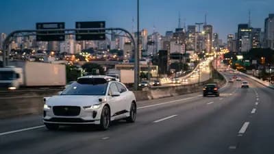 Carro autônomo da Waymo circulando em uma rodovia urbana moderna com sensores de mapeamento no topo do veículo