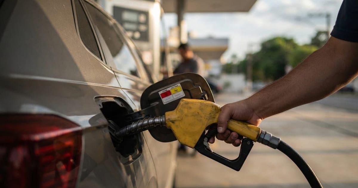 Tanque de combustível de carro sendo abastecido em posto com etiqueta de identificação de gasolina comum e aditivada.