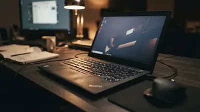 Detalhe de um notebook profissional Lenovo ThinkPad sobre uma mesa de escritório com teclado retroiluminado