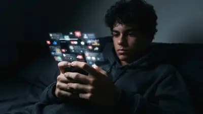 Smartphone sendo usado por um adolescente em um ambiente escuro, com foco nas notificações de redes sociais na tela